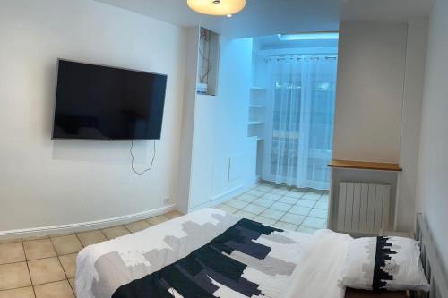 a bedroom with a flat screen tv on a wall at Magnifique appartement in Gentilly