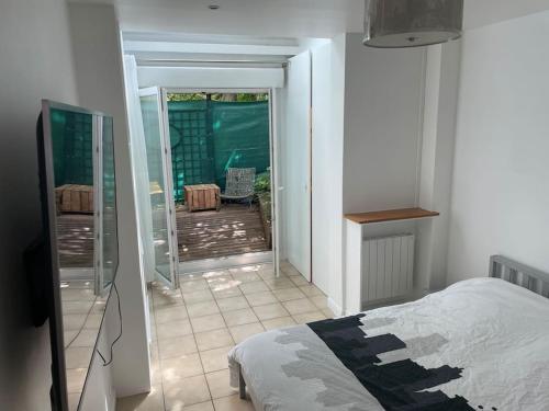 a bedroom with a bed and a view of a patio at Magnifique appartement in Gentilly