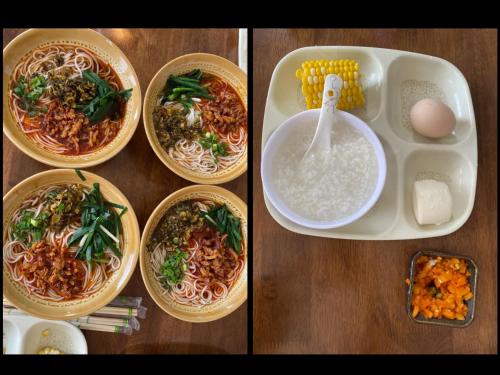 a table with bowls of food and a plate of noodles at Dali Muhai Island Designer Seaview Manor in Dali
