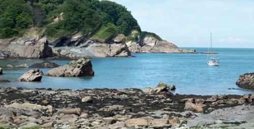 a boat in the water near a rocky beach at Sandaway Holiday Park in Combe Martin
