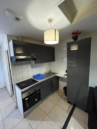 a kitchen with a black refrigerator and a sink at Light Side Self Checkin available in Sarcelles