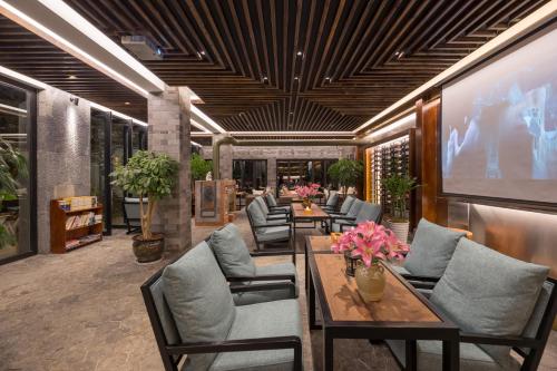 a lobby with tables and chairs and a large screen at Dali Muhai Island Designer Seaview Manor in Dali