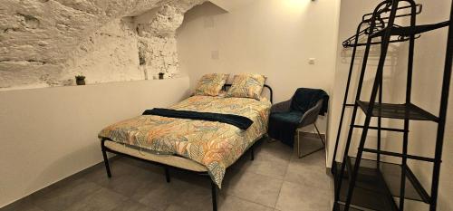 - une chambre avec un lit et un mur en pierre dans l'établissement Appartement mi-troglodyte 4 a 6 personnes de 75 m, à Orléans