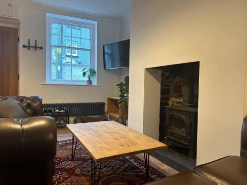 a living room with a table and a fireplace at Charming newly renovated 3 bed cottage in Brecon town with private garden & pets welcome in Brecon