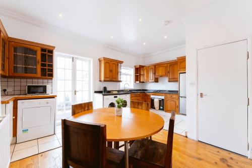 a kitchen with wooden cabinets and a wooden table at White City Double Rooms in London