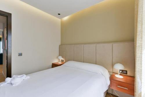 a bedroom with a white bed and two lamps at Sky Blue Suite - Terrace & Ocean View 2BR in Tangier