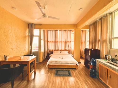 博卡拉Nishan Apartments -Lakeside的一间带床、桌子和电视的卧室