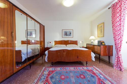 1 Schlafzimmer mit 2 Betten und einem großen Spiegel in der Unterkunft Appartamento il Grillo in Fossato di Vico