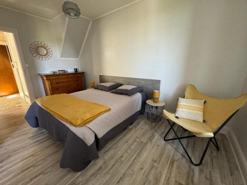 une chambre avec un lit et une chaise dedans dans l'établissement Maison Chez Gilberte à Salers, à Salers