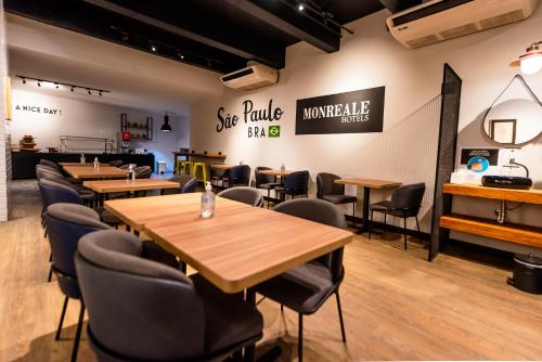 a restaurant with tables and chairs and signs on the wall at Monreale Lifestyle Higienópolis São Paulo in Sao Paulo