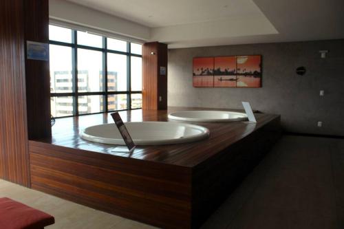 a large bathroom with two tubs in a room at Edf Time, completo e aconchegante, bem localizado in Maceió