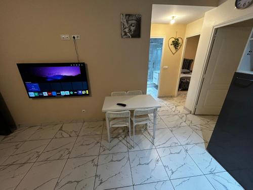 a living room with a table and a tv on the wall at Masion belle vue in Sarcelles