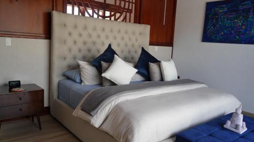 a bedroom with a large bed with blue and white pillows at Hotel Boutique Mitad Del Mundo in Quito