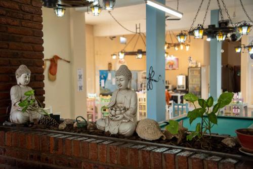 two statues sitting on a shelf with plants at Hotel Ibiza in Villa Gesell