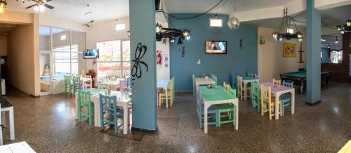 a restaurant with tables and chairs in a room at Hotel Ibiza in Villa Gesell