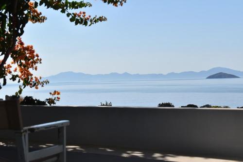 a bench sitting in front of a view of the water at Marathitis cottage house - Aegean sea view in Kanakis