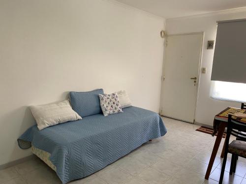 a bedroom with a bed with blue sheets and a screen at Casita María in Puerto San Julián