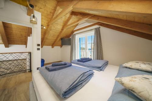 two beds in a room with a window at Villa Dalmatina Charming stone house with pool, 40 m from see in Tribunj