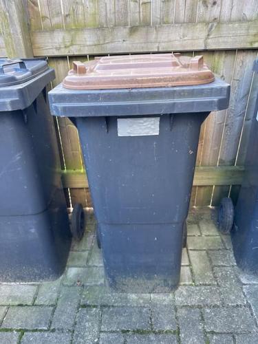 two trash cans sitting next to a wooden fence at VW WERK Wolfsburg Wohnung 4 Betten ein Preis in Oebisfelde