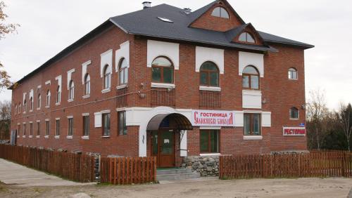 a large red brick building with a black roof at Hotel Solovetskaya Sloboda in Solovetsky Islands