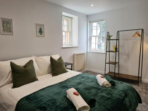 a bedroom with a large bed with towels on it at Royal Retreat Harrogate - FREE parking nearby Ultra fast Wifi in Harrogate
