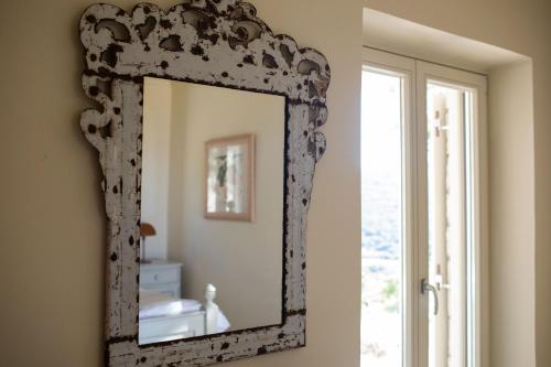 a mirror on a wall in a room with a window at Urania Luxury Villa Geofos in Póndi