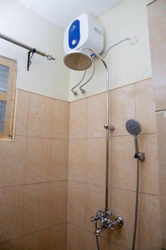 a shower with a shower head in a bathroom at Eden Guesthouse in Bukoto