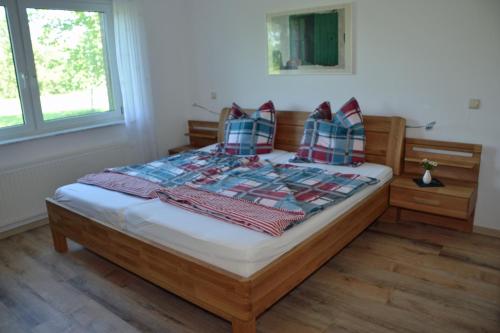 a bedroom with a large bed with plaid pillows at Ferienhaus Storch in Hohnstorf
