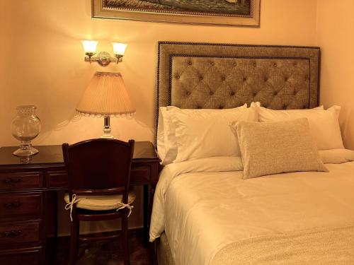 a bedroom with a bed with a chair and a desk at Hotel Boutique Patio Andaluz Cali Granada in Cali