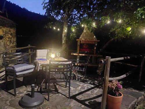 a patio with chairs and a grill at night at Casa da Mata de Fajão in Pampilhosa da Serra