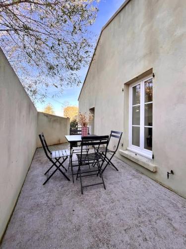 un patio avec une table et des chaises à côté d'un bâtiment dans l'établissement Appartement de charme avec Mezzanine, à Bastia