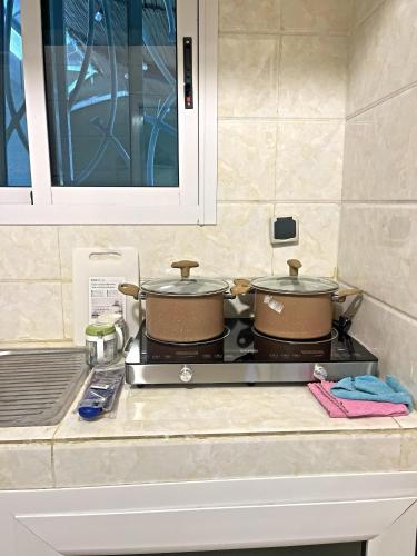 zwei Töpfe auf dem Herd in der Küche in der Unterkunft Studio Meublé de Haut Standing in Abidjan