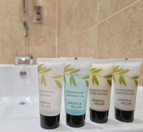 a group of three bottles of bathroom products on a counter at Royal Retreat Harrogate - FREE parking nearby Ultra fast Wifi in Harrogate