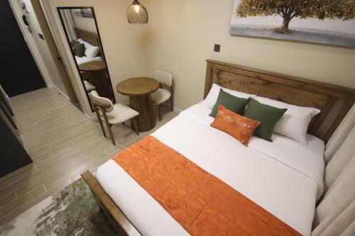 a bedroom with a bed and a table and a mirror at Pristine Homes Studio Apartment - Mombasa Road in Nairobi