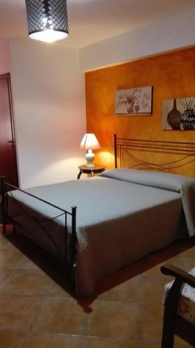 a bedroom with a large bed with a lamp on a table at Bed and breakfast Agrumi in terrazza in Aragona