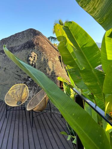 a couple of chairs sitting on a deck at Pousada Vila das Pedras in Ilhabela