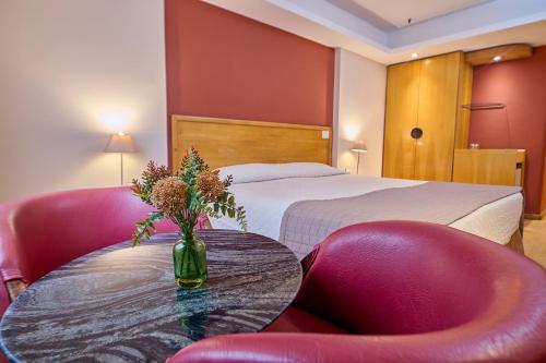 a hotel room with a bed and a table and chairs at South American Copacabana Hotel in Rio de Janeiro