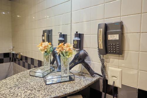 a phone and flowers on a counter in a bathroom at South American Copacabana Hotel in Rio de Janeiro