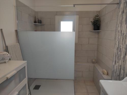 a white bathroom with a shower and a tub at Maison au milieu des vignes in Vacqueyras