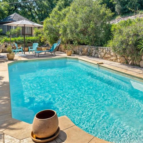 - une piscine avec un chapeau au au milieu dans l'établissement Terrasse, Piscine privée & Charme provençal, à Tourrettes-sur-Loup