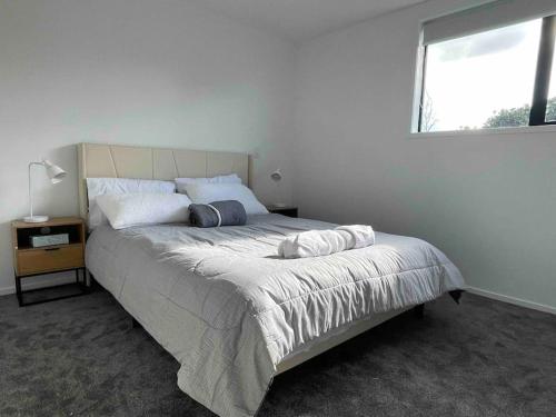 a bedroom with a large bed with a window at Coastal Sanctuary in Christchurch