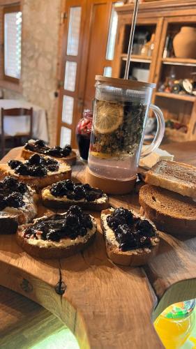 a wooden table with bread and a jar of jam at Crâșma Trei Fântâni - Cebotaru in Hogineşti