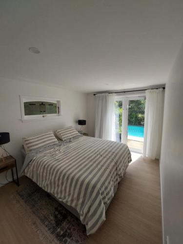 a white bedroom with a bed and a large window at Auckland Central City Oasis in Auckland