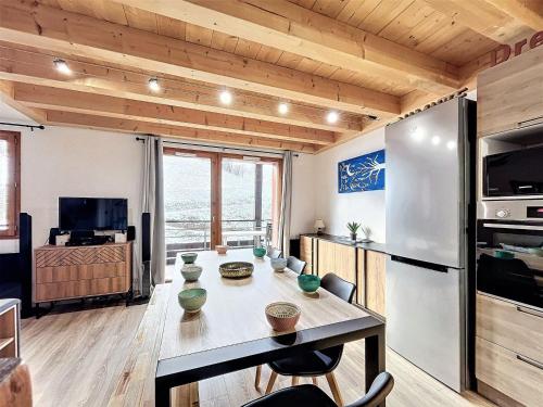 Il dispose d'une cuisine et d'un salon avec une table et un réfrigérateur. dans l'établissement Duplex rénové, 8/10 pers, skis aux pieds, balcon sud, calme, piscine chauffée - FR-1-267-180, au Corbier