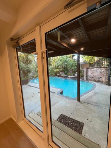 a sliding glass door with a view of a swimming pool at Auckland Central City Oasis in Auckland