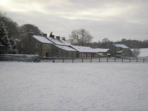 a house covered in snow with a fence at Green Grove Country House in Malham