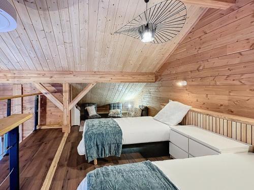 two beds in a room with wooden walls at Chalet 6 pers, WiFi, parking, proche pistes - FR-1-267-297 in Villarembert