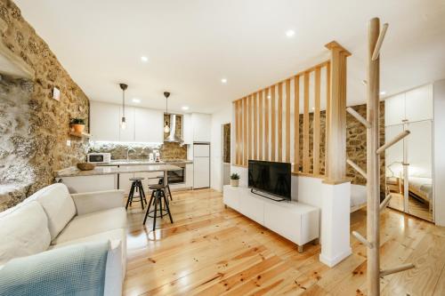 a living room with a white couch and a kitchen at Casa do Castelo in Covilhã