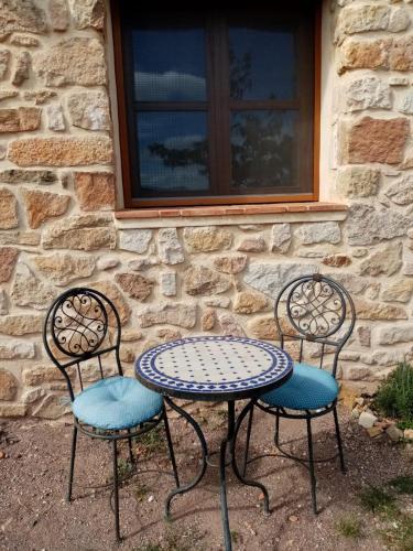 a table and two chairs sitting in front of a building at El Cubo de Sebastián in Olba