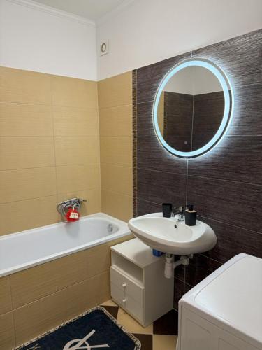 a bathroom with a sink and a tub and a mirror at Mimi Apartman in Debrecen